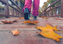 Schoenmerken die in de behoefte aan gezonde voeten voorzien vrouw die door park loopt